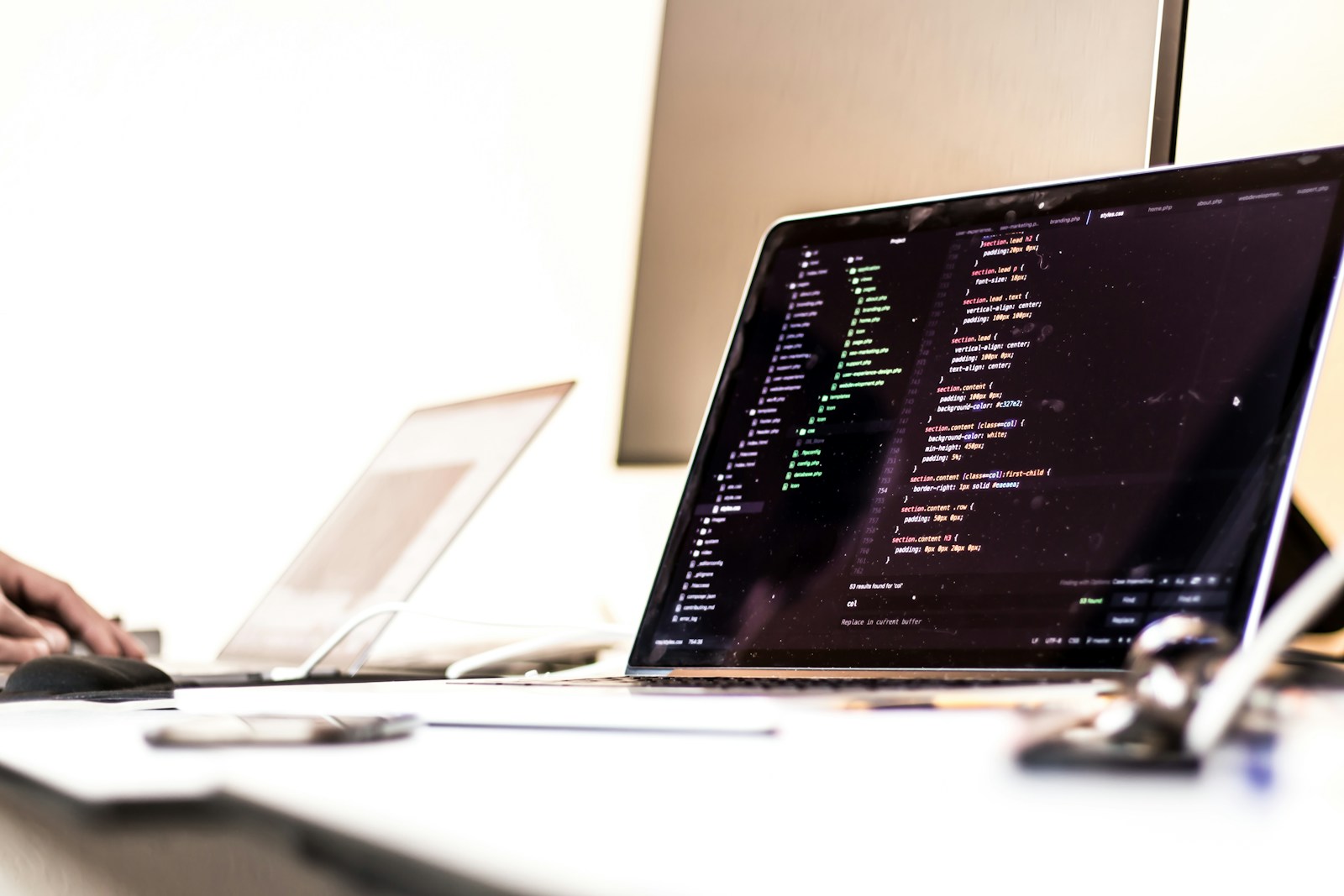 A laptop displaying source code in a software development workspace
